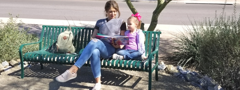 mother and child read outdoors in the monarch haven